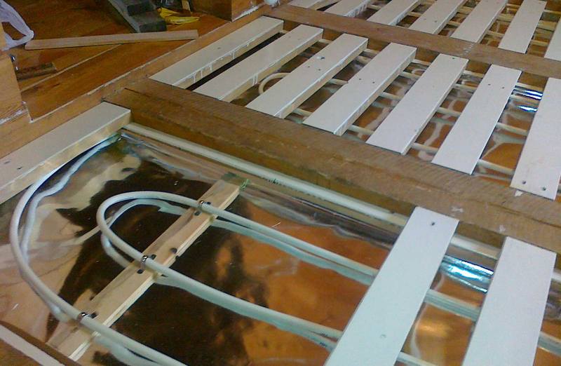 При обладнанні теплої підлоги на другому поверсі дерев'яного будинку практичніше за все застосувати рейкову систему